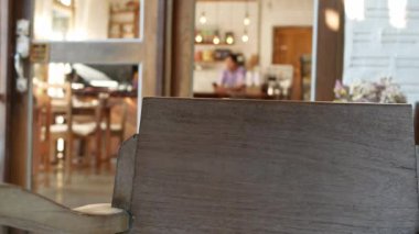 Güzel, genç bir kafe sahibi içeride müşterileri bekliyor. Seçmeli odak.