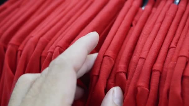 Frauenhände Laufen Über Kleiderständer Und Wählen Den Pullover — Stockvideo