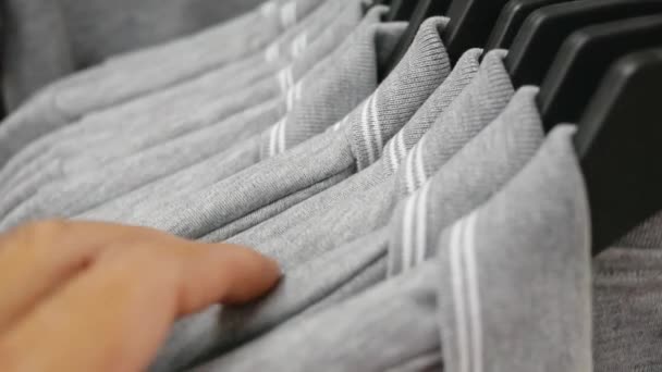 Fechar Mãos Homem Correr Através Rack Roupas Escolhe Camisa — Vídeo de Stock
