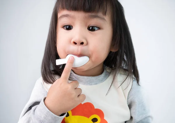 Petite fille malade mignonne prenant des médicaments isolés sur fond gris — Photo