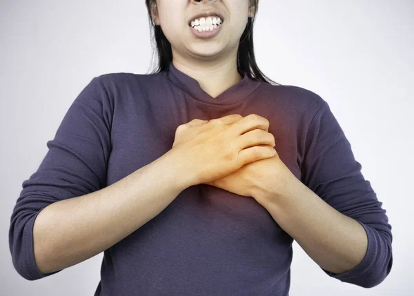 Mujer cogiendo en el pecho porque tiene dolor de enfermedades del corazón — Foto de Stock