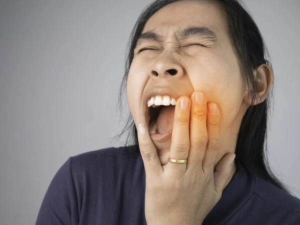 Mulher pegando na bochecha porque ela tem uma dor de dente. Serviços de saúde — Fotografia de Stock