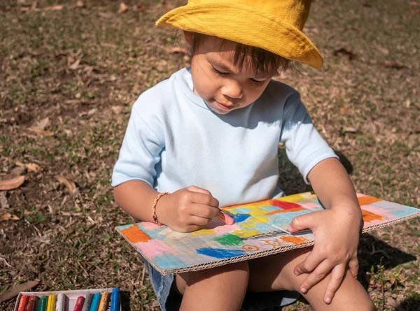 Το μικρό κορίτσι καλλιτέχνης κάθεται και ζωγραφίζει στα ανακυκλώσιμα — Φωτογραφία Αρχείου