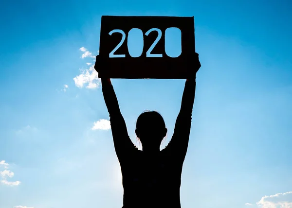 Silhouette of woman holding recycle cardboard with 2020 text ove — Stock Photo, Image
