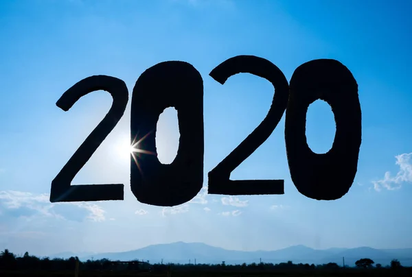 Kartonu mavi gökyüzü arkaplanı üzerinde 2020 numaraya geri dönüştür ve — Stok fotoğraf