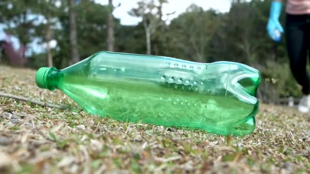 Hand Hand Mit Handschuhen Hebt Eine Plastikflasche Aus Dem Gras — Stockvideo