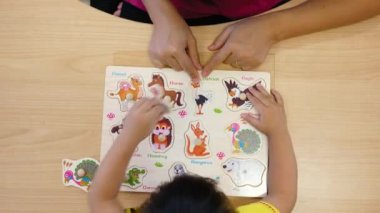 Sınıfta meyve ve sebze öğrenmek için montessori ahşap malzemelerle oynayan sevimli küçük kız çocuğu. Küçük çocuklar için eğitici oyuncaklar kavramı.