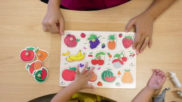 Roztomilé holčička baví hrát si s montessori dřevěný materiál pro ovoce a zeleninu učení ve třídě místnosti. Koncepce vzdělávacích hraček pro malé děti.