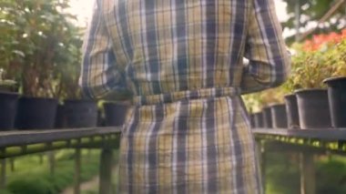 Serada dijital tablet kullanan Asyalı genç kadın çiftçi. Tablet bilgisayar kullanan çiftçi tarım alanında çalışıyordu..