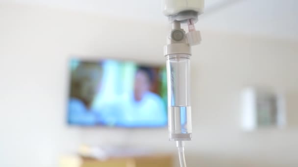 患者と注入ポンプのためのサラインソリューションドリップのクローズアップは 病院でのぼやけた豪華なVipルームの背景にあります — ストック動画