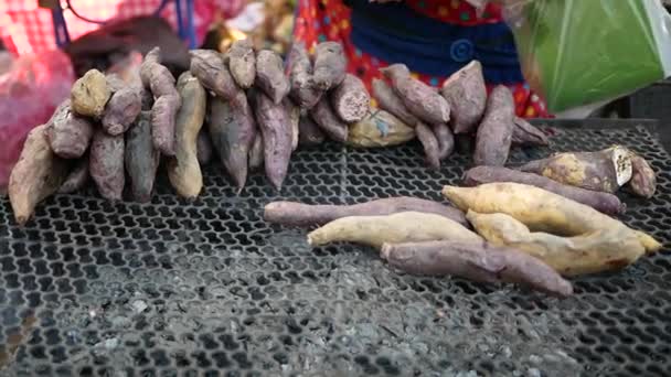 冬季新鲜市场炭炉上美味的烤有机红薯紫色和黄色 — 图库视频影像