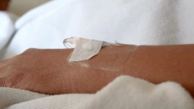 Hastanın elinin damardan sıvı aldığı ve hastanedeki lüks Vip odasının arka planında bulunan bir damara girdiği görüntüler. Hastaneye yatırılan Asyalı kadın..