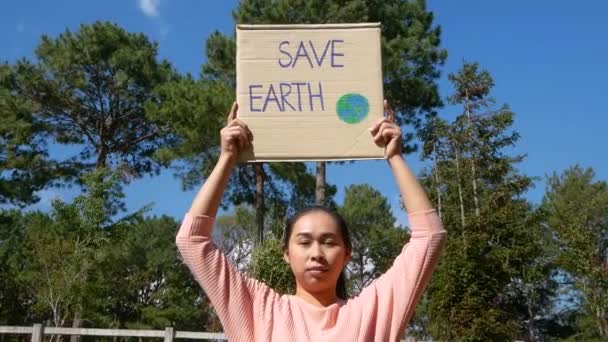 拯救地球 海报的年轻女子展示了一个抗议森林中塑料污染的标语 世界环境日的概念 零废物 — 图库视频影像