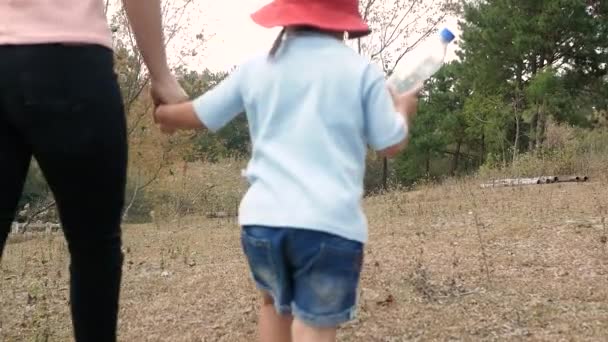 Mulheres Caminham Com Filha Jogam Garrafas Plástico Chão Jardim Refletindo — Vídeo de Stock