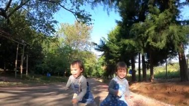 İki kardeş bir yaz parkında oyun oynarken eğleniyorlar. Mutlu aile ve çocukluk kavramı.