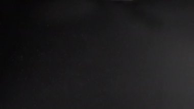 The mist of a spray bottle spraying water into the air on dark background.