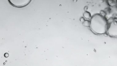 Air bubbles in the water while pouring water in glass, Photos from the underwater corner. Creative abstract background, Silver tone style.