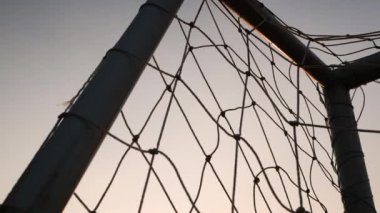 Stadyumda gün batımında arka planda olan futbol golü.