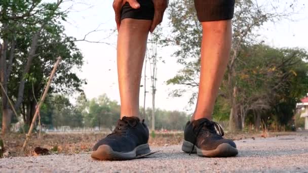 公園でジョギングした後 膝の痛みに苦しんでいるため アジアの高齢者の男性は膝の上に手を使用します 医療の概念 — ストック動画