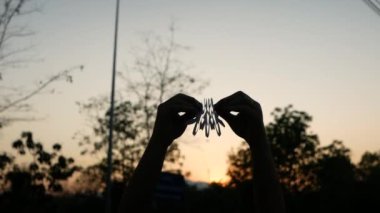 Gün batımında parkın arka planında el ele tutuşan kağıt zincire bağlı insanlarla takım çalışması kavramı.