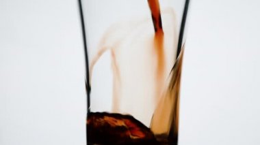 Beyaz arka planda izole edilmiş meyve suyunu bardağa boşalt..