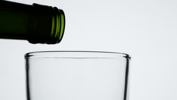 将果汁从绿瓶中倒入玻璃杯中 在白色背景下隔离 — 图库视频影像