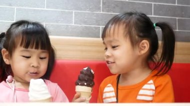 Asyalı küçük kız servis atölyesinde dondurma yerken eğleniyor. KFC dünyaca ünlü bir Amerikan fast food restoranıdır. Sağlık kavramı.