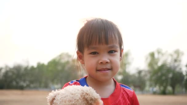 Милая Азиатская Девочка Обнимает Плюшевого Мишку Чувством Любви Общественном Парке — стоковое видео
