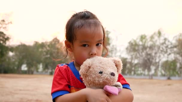 Carino Asiatico Bambina Abbracciare Orsacchiotto Con Sentimento Amore Pubblico Parco — Video Stock