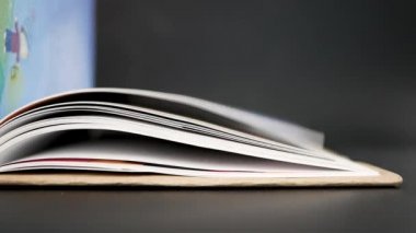 Kadın 'ın karanlık arka planla ilgili bir kitabın sayfalarını çevirişinin kapanışı. Seçici odak.