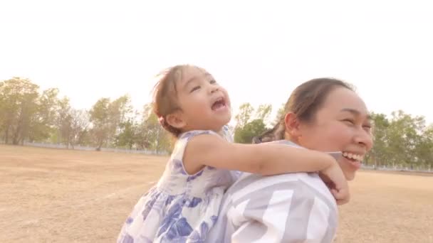 Menina Criança Feliz Sentada Parte Trás Mãe Correndo Parque Conceito — Vídeo de Stock