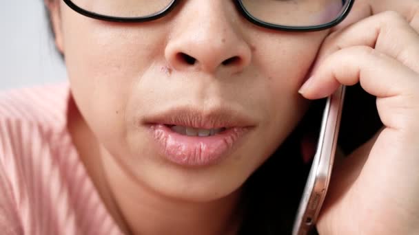 合上没有化妆的女性嘴唇的肖像 戴着眼镜在手机上愉快地说话 面带微笑 专注于嘴唇 — 图库视频影像