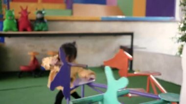 Asyalı genç anne ve kız çocuk parkında birlikte oynayarak eğleniyorlar. Mutlu aile ve çocukluk kavramı.