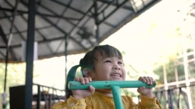 Asyalı genç anne ve kız çocuk parkında birlikte oynayarak eğleniyorlar. Mutlu aile ve çocukluk kavramı.