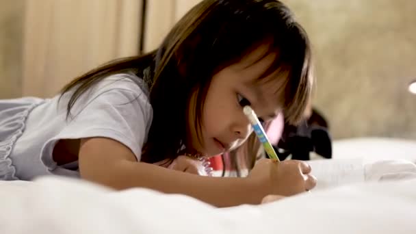 Schattig Klein Kind Meisje Doet Haar Huiswerk Bed Thuis — Stockvideo
