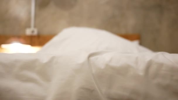 幼い母親と娘は寝室でPeekabooを楽しむことができます 幸せな家族のベッドの上で白い毛布の下で遊んでいる 幸せな家庭と子供時代の概念 — ストック動画