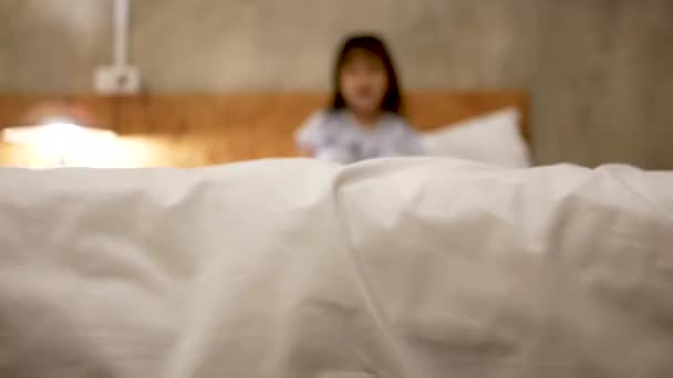 年轻的母亲和她的女儿们在卧室里玩躲猫猫 快乐的家庭在床上的白色毯子下玩耍 幸福家庭和童年的概念 — 图库视频影像