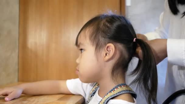 年轻可爱的小女孩站在卧室的椅子上 微笑着看着镜子 妈妈在梳理她的头发 — 图库视频影像