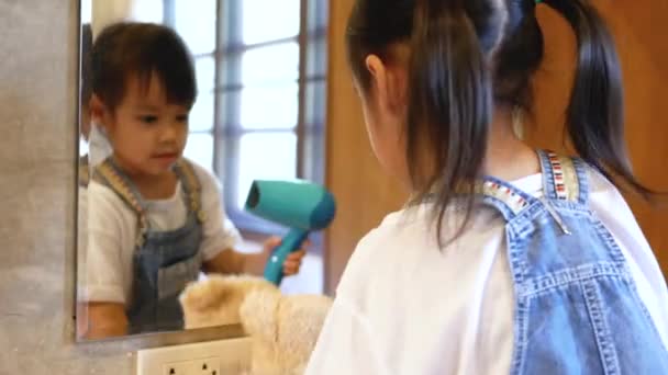 Nettes Lächelndes Kleines Mädchen Spielt Einen Fön Mit Teddypuppe Spiegel — Stockvideo