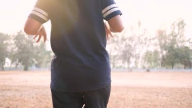 Asyalı genç bir kadın sağlık için parkta koşmadan önce bacaklarını esnetiyor. Sağlık hizmetleri kavramı.