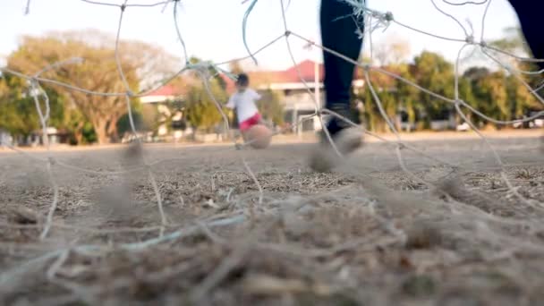 Mladá matka a její dcera se baví hraním fotbalu v letním parku. Koncept šťastné rodiny a dětství.