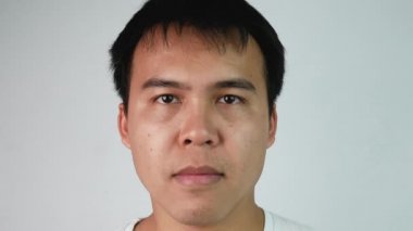 Öfkeli Asyalı adamın hayal kırıklığını ifade eden portresi ve gri arka plan. Duygu ve ifade kavramları.