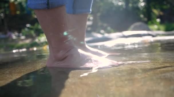 年轻女子赤脚在溪流中的水里泼洒和踢腿 水流缓慢 女士们在瀑布边享受与大自然同行的假期 暑假生活方式的概念 — 图库视频影像