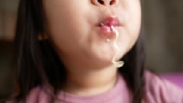 家庭でプラスチックカップに麺を食べるのが楽しいアジアの小さな子供の女の子 ジャンクフードのコンセプト — ストック動画