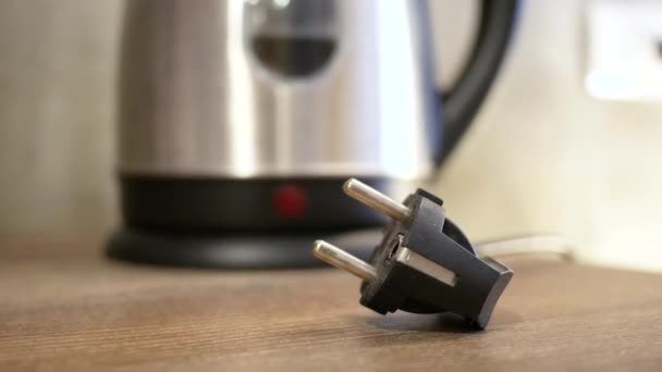 Bouilloire électrique en acier inoxydable avec eau bouillante dans la cuisine, préparation de boissons chaudes, cliquez sur le bouton .