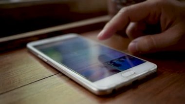 Bayramlarda kafede dinlenmek için akıllı telefondan kadınların parmak ekranına yakın çekim yapın..