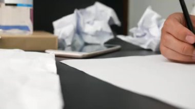Genç stresli bir kadın küçük bir ofiste ya da işine kızgın bir şekilde masa başında oturuyor, hayal kırıklığına uğramış vücut ifadeleri ile buruşmuş belgeler ve etrafa kağıt parçaları saçıyor. Negatif insani duygu kavramı.