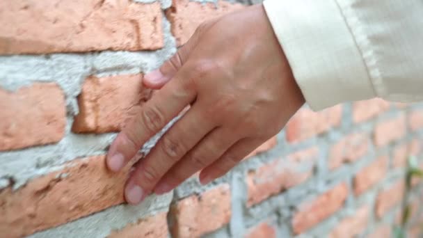 レンガのハードラフな表面に触れる女性の手を閉じる 屋外の家の壁の一部 — ストック動画