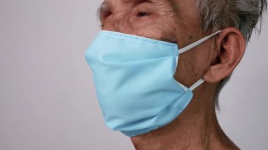 Hava kirliliğinden ya da gri arka planda virüs salgınından korunmak için ev yapımı koruyucu yüz maskesi takan Asyalı son sınıf öğrencileri. Sağlık hizmeti kavramı.