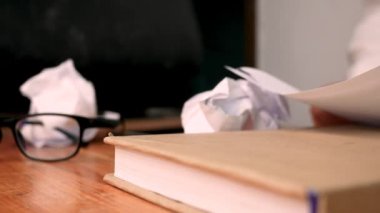 Genç, stresli bir kadın küçük bir ofiste ya da işine kızgın bir şekilde masada oturuyor, hayal kırıklığına uğramış vücut ifadesiyle masayı parçalıyor ve etrafa kağıt parçaları saçıyor. Negatif insani duygu kavramı